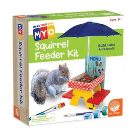 The MYO Squirrel Feeder Kit by MindWare features a colorful box showcasing a DIY kit for children aged 5 and up. The packaging displays a cheerful illustration of a squirrel and a small, red and yellow picnic-style feeder complete with an umbrella, along with paint and decorative elements. The text 'Build, Paint & Decorate' emphasizes its creative, hands-on approach for young crafters.