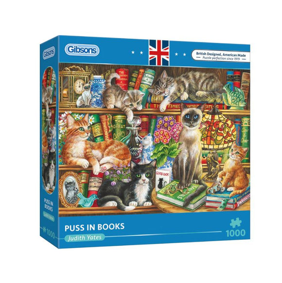 Puss in Books jigsaw puzzle by Gibsons featuring a colorful illustration of various cats lounging on bookshelves surrounded by a variety of books and knick-knacks. The box displays the title and artist Judith Yates, highlighting the vibrant and detailed artwork designed for puzzle enthusiasts.