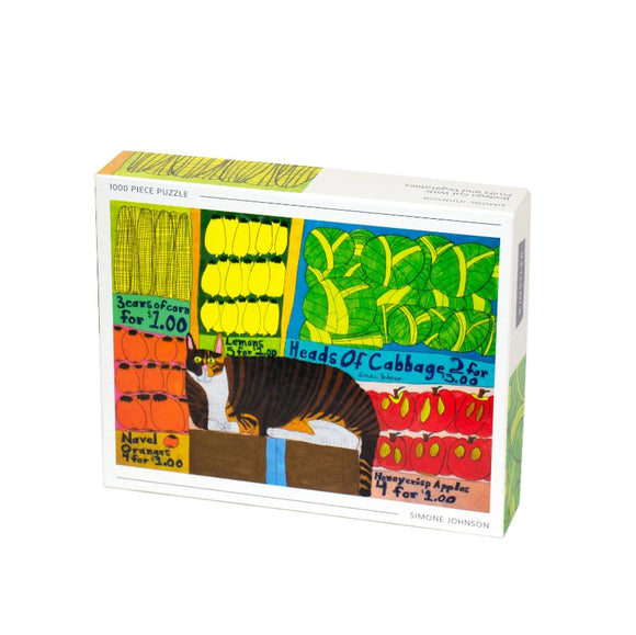 Bodega Cat jigsaw puzzle by Kinstler featuring a colorful illustration with a tabby cat and various fruits and vegetables. The puzzle consists of 1000 pieces and showcases items like corn, lemons, cabbage, and oranges in a vibrant, whimsical design.