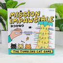 Mission Impawsible game by Gift Republic featuring a fun illustration of a hand removing colorful sticks from a tower. The game includes cute cat characters and instructions to avoid making the cats fall, making it ideal for family fun and gatherings.