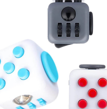 A vibrant assortment of Fidget Cubes made by Antsy Labs. The cubes feature various textures and buttons, including smooth and clickable surfaces in different colors such as blue, gray, and red. Ideal for stress relief and keeping hands busy.