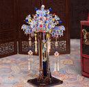 A beautifully crafted stand for Coronet Metal Models, featuring intricate designs and colorful decorations. The stand showcases vibrant beads and detailed craftsmanship, perfect for displaying model creations. It stands on a sturdy base, enhancing the aesthetic appeal of any model collection.