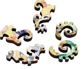 Five intricately cut wooden pieces of the 'Lady with Fan' jigsaw puzzle by Artifact Wooden Puzzles. Each piece showcases colorful swirls and details inspired by Klimt's artwork.