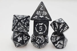 Drake's Flight: Nightmare RPG game features an assortment of beautifully designed black and white polyhedral dice, each displaying unique symbols and numbers. The collection includes various shaped dice like d4, d6, d8, d10, d12, and d20. Perfect for enhancing tabletop gaming experiences.