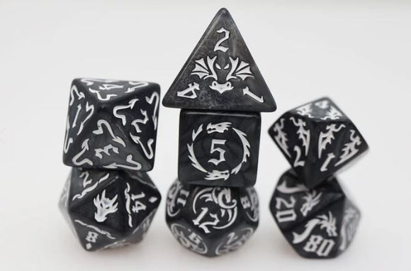 Drake's Flight: Nightmare RPG game features an assortment of beautifully designed black and white polyhedral dice, each displaying unique symbols and numbers. The collection includes various shaped dice like d4, d6, d8, d10, d12, and d20. Perfect for enhancing tabletop gaming experiences.