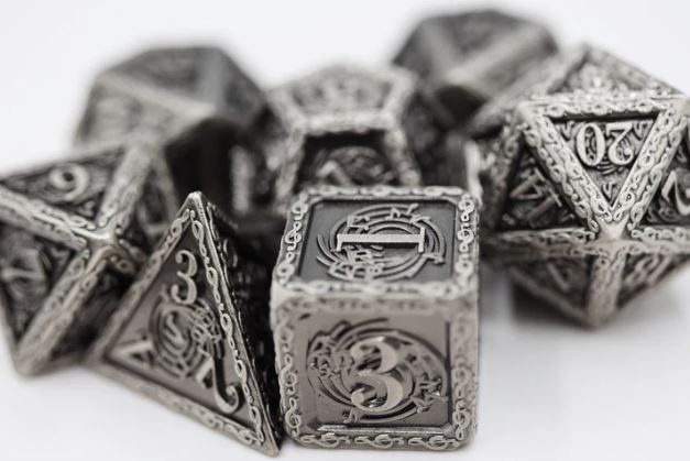 A collection of intricately designed metallic RPG dice, including various shapes like d4, d8, d10, d12, and d20. Each die features decorative engravings and numbers, showcasing a fantasy theme perfect for tabletop gaming enthusiasts.