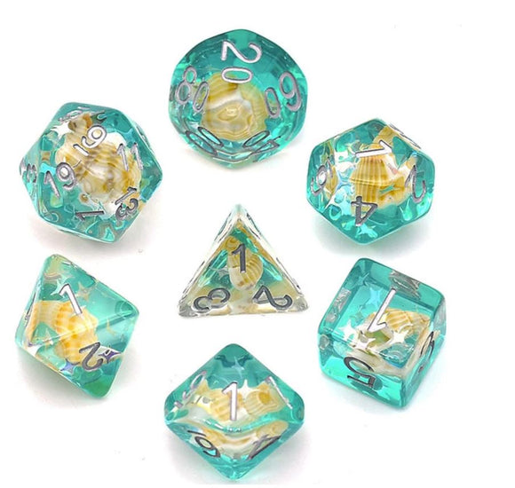 A vibrant Green Conch RPG Dice Set made by Foam Brain Games. This seven-piece dice set features stunning turquoise resin with embedded seashell designs, perfect for tabletop role-playing games. Each die is intricately detailed with silver numbers, showcasing a mix of traditional polyhedral shapes, including a d20, d12, d10, d8, d6, and d4. Ideal for enhancing your gaming experience.