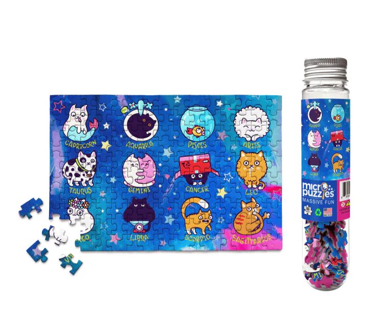 Catstrology Micro Puzzle featuring colorful, cartoonish cats representing zodiac signs against a cosmic backdrop. Includes several loose puzzle pieces and comes in a clear tube packaging labeled with Micro Puzzles branding.