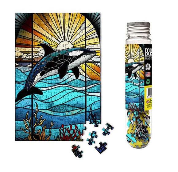 Stained Glass Orca marine jigsaw puzzle featuring a stunning orca whale design in vibrant colors. The puzzle shows a sunrise and ocean waves, with several puzzle pieces displayed next to it and packaged in a transparent bottle.