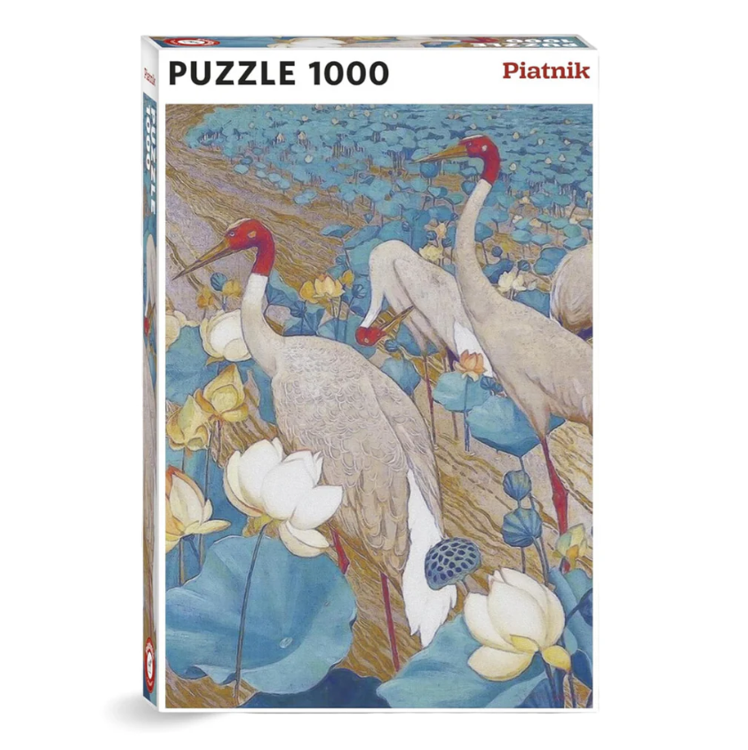 The Ying Yang Plumage jigsaw puzzle by Piatnik features an intricate illustration of cranes amidst vibrant blue lotus flowers and leaves. The puzzle has 1000 pieces, showcasing a serene and beautiful nature scene.