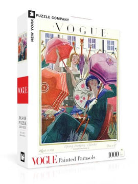 A 1000-piece jigsaw puzzle titled 'Painted Parasols' by New York Puzzle Company. The box displays a colorful vintage illustration featuring women with ornate parasols in a spring shopping scene. The artwork is reminiscent of a Vogue magazine cover from 1923, highlighting elegant fashion and vibrant colors.