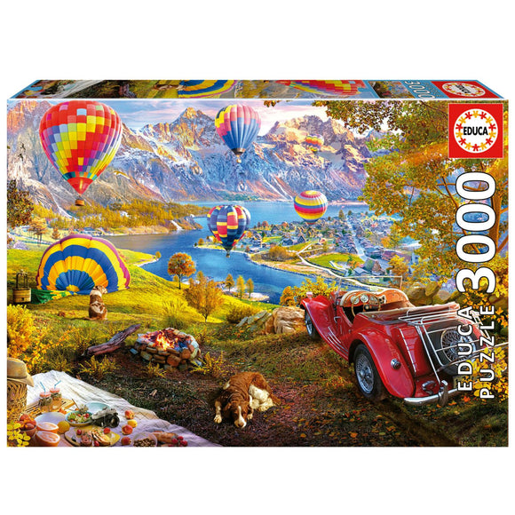 Educa jigsaw puzzle titled 'Hot Air Balloon Valley' featuring a colorful landscape with hot air balloons in the sky, a serene lake, a classic red car, and a peaceful dog resting in a vibrant autumn setting.