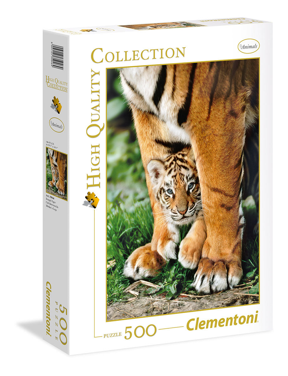 The Bengal Tiger Cub jigsaw puzzle box featuring a captivating image of a playful tiger cub nestled among its mother's paws, surrounded by lush greenery. It includes 500 high-quality pieces, perfect for puzzle enthusiasts and animal lovers.