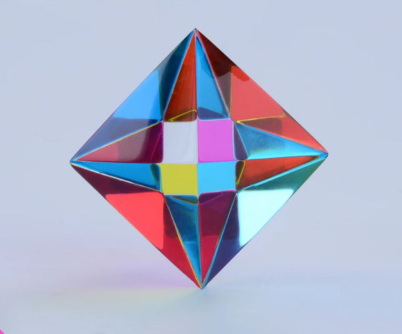 The Aether by CMY Cubes is a dazzling, iridescent pyramid-shaped fidget toy, reflecting vibrant colors of red, blue, yellow, and pink. Its polished surface catches light beautifully, enhancing its playful design, perfect for stress relief and sensory exploration.