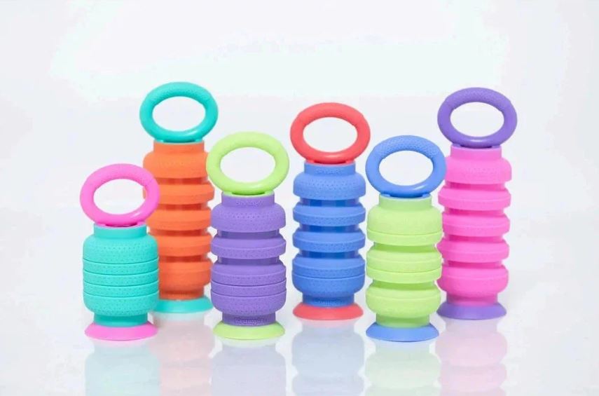 A colorful collection of Krumples Fidget toys from Smart Toys & Games. The fidgets feature various vibrant colors including pink, green, blue, orange, and purple. They have a unique design with flexible rings stacked in different arrangements, creating a playful look. Ideal for stress relief and sensory stimulation.