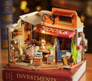 A detailed miniature DIY kit of a corner bookstore, featuring an inviting facade with 'BOOKS' signage, colorful potted plants, and cozy interiors filled with bookshelves, a desk, and decorative items. The charming design includes outdoor seating and warm lighting, ideal for book lovers and craft enthusiasts.