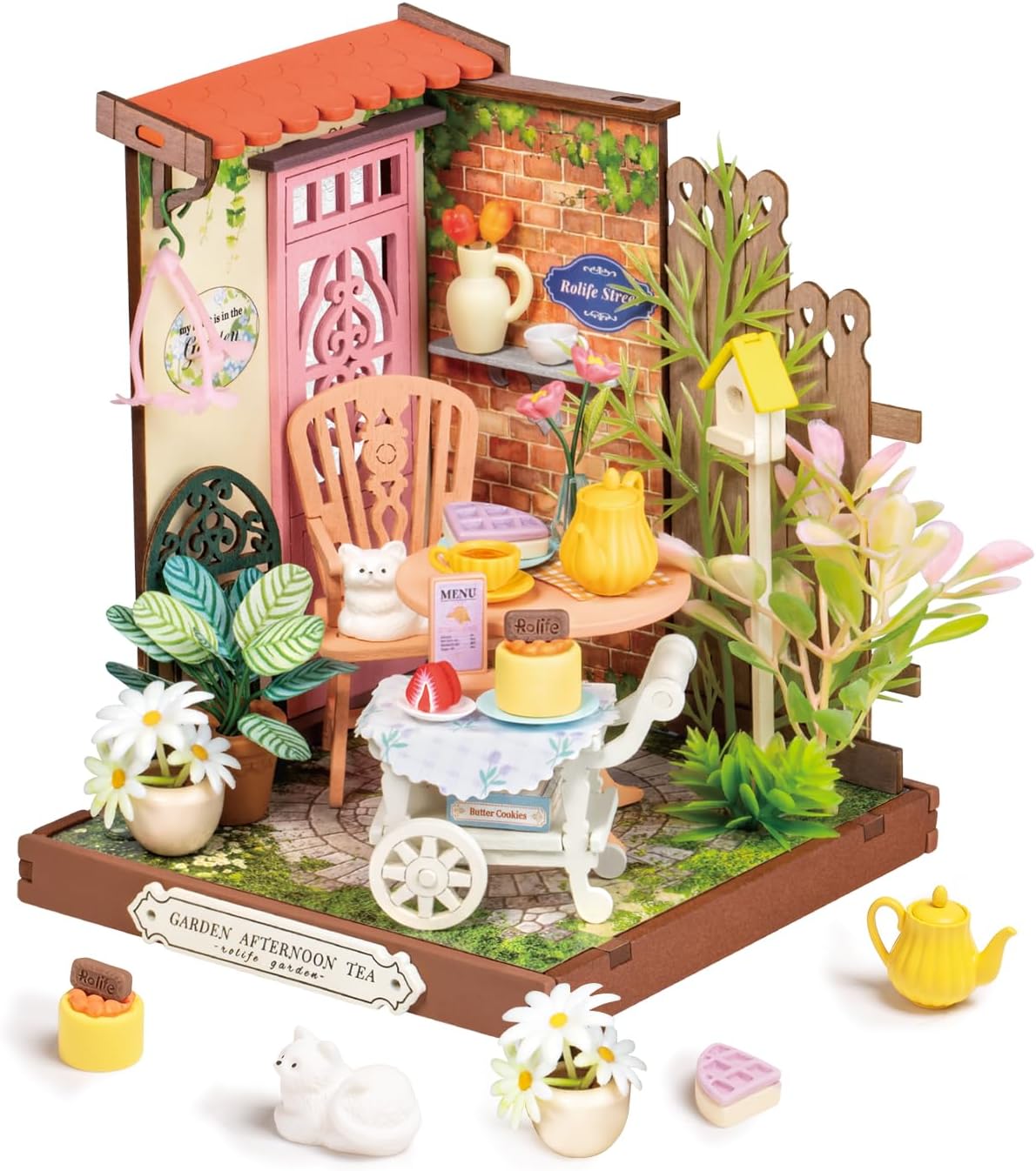 A charming DIY tea yard kit by Robortime featuring a detailed miniature setup with a pink door, wooden chair, table with tea sets, and decorative plants. The scene includes pastries, a cat figurine, and a lovely garden ambiance, perfect for a delightful afternoon tea experience.