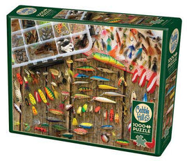 Cobble Hill Fishing Lures jigsaw puzzle featuring a detailed image of various fishing lures displayed on a rustic wooden board. The puzzle box artwork showcases bright colors and intricate designs of the lures, with a variety of shapes and patterns, perfect for fishing enthusiasts and jigsaw puzzle lovers alike.