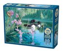 Cobble Hill 500-piece jigsaw puzzle titled 'Iris Cove Loons'. The box features a serene image of two loons swimming in calm water, surrounded by vibrant purple flowers and a butterfly. The background includes lush greenery and reflections on the water, beautifully illustrating a tranquil natural setting.