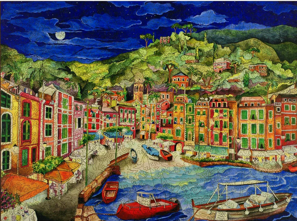A vibrant jigsaw puzzle depicting the picturesque harbor of Portofino, Italy. The scene features colorful buildings lining the waterfront, boats gently bobbing in the water, and a lush green hillside with palm trees under a starry night sky. The intricate artwork captures the charm and beauty of this Italian coastal village.