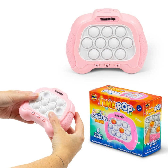 The Time Pop Light-Up Game features a pink handheld device with nine white buttons arranged in a grid. A person is holding the device while pressing the buttons. The product box displays colorful artwork with the game title, highlighting five game modes and interactive play. Ideal for ages 5 and up, this game promises fun and engaging gameplay.