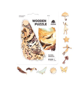 The Flying Whales Piecezz Puzzle P by GEEK Toys US showcases an assortment of intricately cut wooden pieces. These pieces feature whimsical shapes including whales, butterflies, and other fantasy elements, designed for an engaging jigsaw puzzle experience. The packaging highlights a vibrant illustration of flying whales against a beautiful sky, emphasizing the unique theme of the puzzle.