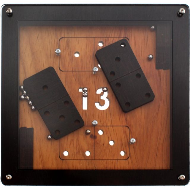 A mechanical puzzle featuring a wooden panel with the number 13 displayed prominently. The design includes two black domino-like pieces resting on the surface. The puzzle requires strategic movement to solve, inviting engaging mental challenges.