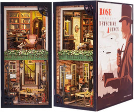 The Rose Detective Agency bookend by Cute Bee features a beautifully crafted design with intricate details of a detective's office. The bookend showcases a charming scene with a brick building facade, a wooden sign reading 'THE DETECTIVE HOUSE', and a cozy interior filled with vintage furniture, books, and decorative items. It stands as an artistic and functional piece, perfect for organizing books while adding a touch of whimsy to your space.