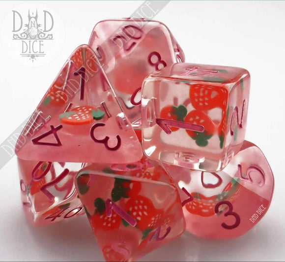 A vibrant set of Strawberry Shortcake RPG dice featuring a variety of shapes, including dice with strawberries and green leaves embedded within the translucent pink material. The numbers are displayed in bold purple ink, enhancing the whimsical design suitable for tabletop gaming enthusiasts.