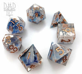 A set of seven beautifully crafted gravitational wave acrylic RPG dice by DND Dice. Each die features a unique blend of translucent blue and clear acrylic, accented with shimmering copper numbers for easy readability. The shapes include various polyhedral designs, ideal for tabletop gaming.