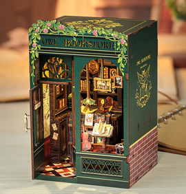 The Owl Bookstore Book Nook by Cuteebe features a charming miniature bookstore design with detailed interior elements including bookshelves filled with books, art frames on the wall, a cozy reading lamp, and an inviting open door, all adorned with floral accents. Perfect for DIY enthusiasts and collectors of unique decor.