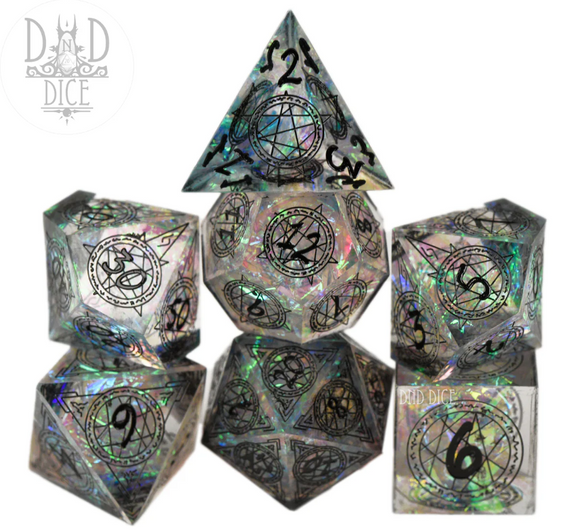 Crown of Stars 7pc Dice Set displayed in an arrangement showcasing various polyhedral dice. Each die features intricate black engravings and a shimmering iridescent finish, perfect for tabletop gaming.