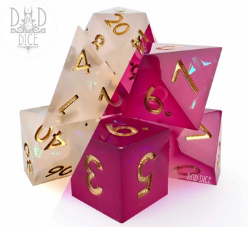A collection of vibrant polyhedral dice in shades of translucent pink and clear, featuring golden numbers. The dice are displayed in a dynamic, stacked arrangement, showcasing their unique shapes and colors, perfect for tabletop gaming.