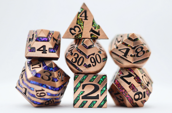 A collection of intricately designed copper dice featuring various shapes such as pyramids and cubes. The dice are embellished with colorful glitter and engraved numbers, showcasing distinctive patterns. This set is perfect for tabletop gaming enthusiasts and adds a vibrant touch to any game night.