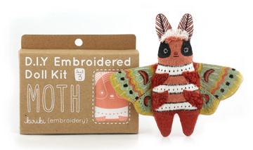 A DIY Embroidered Doll Kit featuring a colorful moth doll from Kiriki Press. The kit is designed for level 3 crafters and includes the doll with vibrant embroidered wings and facial features. The packaging showcases a cute illustration of the moth and highlights its artistic embroidery elements.