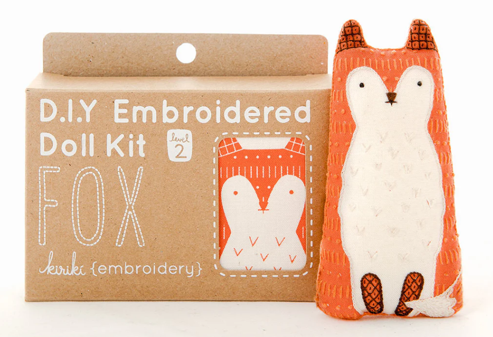 Fox Doll Embroidery Kit by Kiriki Press, featuring a charming fox design, packaged in a lightweight cardboard box. The kit includes materials for creating a cute embroidered doll, perfect for intermediate crafters. The front highlights the fox doll illustration and the kit level.