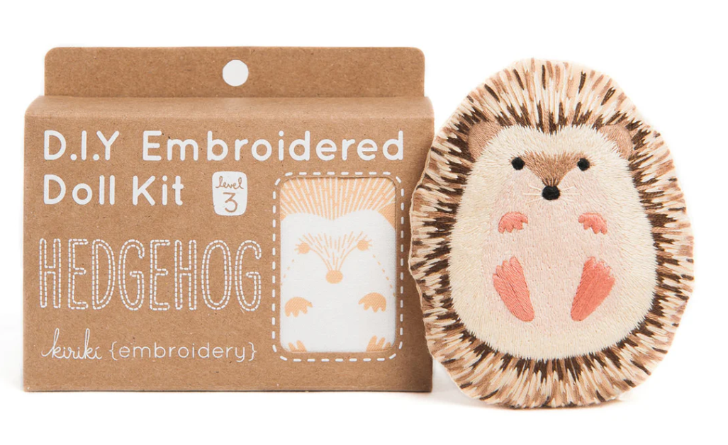 A Hedgehog Doll Embroidery Kit from Kiriki Press displayed in its packaging. The kit features a charming hedgehog design, with vibrant embroidery detailing and a rustic cardboard box labeled as level 3 for DIY embroidery projects.