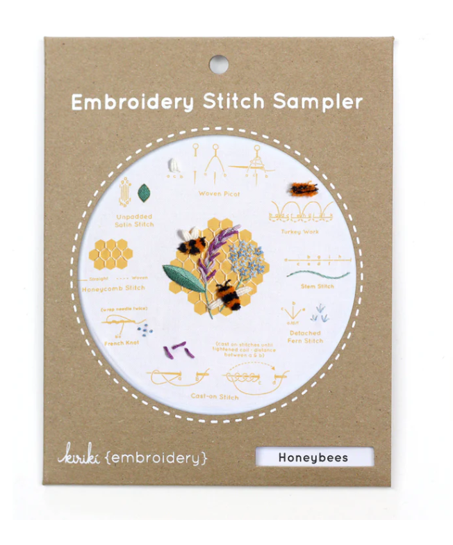 The Honeybees Embroidery Stitch Sampler from Kiriki Press features a visually appealing arrangement of embroidery stitch instructions, including detailed illustrations of stitches such as Honeycomb, French Knot, and Stem Stitch. This DIY embroidery kit highlights a honeybee and floral design, making it perfect for embroidery enthusiasts.