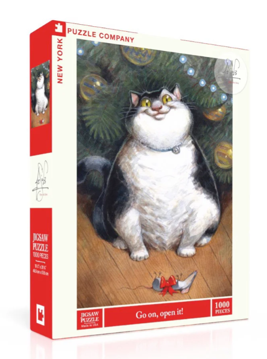 A colorful jigsaw puzzle by New York Puzzle Company featuring a cheerful black and white cat sitting by a Christmas tree, adorned with ornaments. The puzzle box displays the title 'Go on, open it!' prominently, and it contains 1000 pieces, perfect for puzzle enthusiasts.