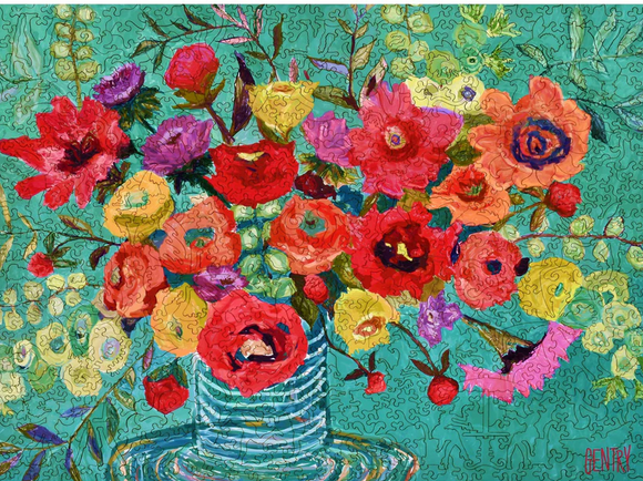 A vibrant jigsaw puzzle depicting a striking arrangement of colorful flowers in a glass vase on a teal background. The artwork features various blooms in shades of red, yellow, purple, and orange, with intricate details bringing the scene to life.