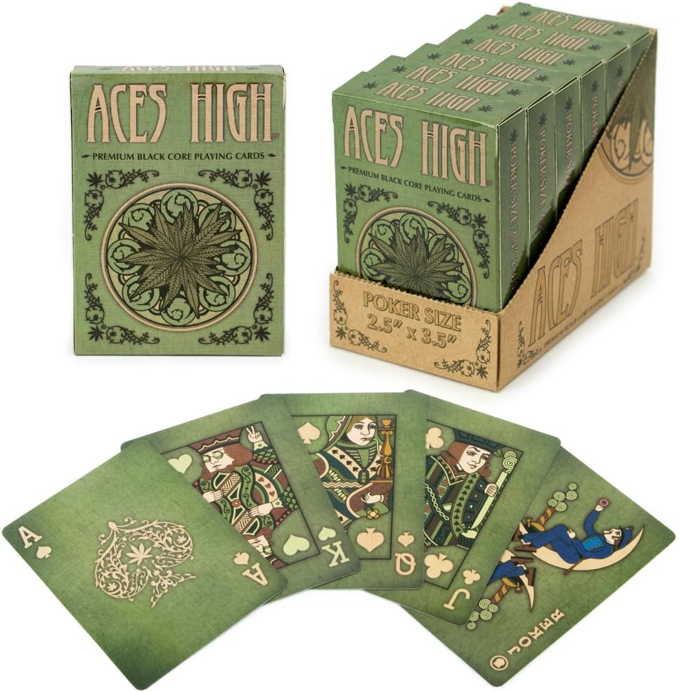 Aces High playing cards by Brybelly, featuring a beautifully designed deck with premium black core. The box is green with intricate patterns, displayed alongside several poker-sized cards showing various illustrations, including the Ace of Spades, King, and others, all set against a green background.