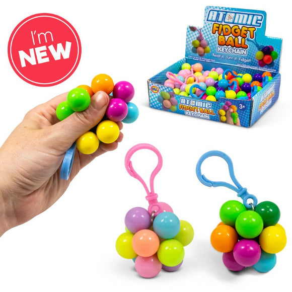 The Atomic Fidget Keyring by One for Fun features a colorful fidget ball keychain held in a hand, showcasing vibrant orbs in multiple colors including pink, yellow, blue, green, and orange. Two additional keyrings are visible in pink and blue holders, also displaying colorful bundles of fidget balls. The display box in the background highlights the product along with a banner stating 'I'm NEW'.