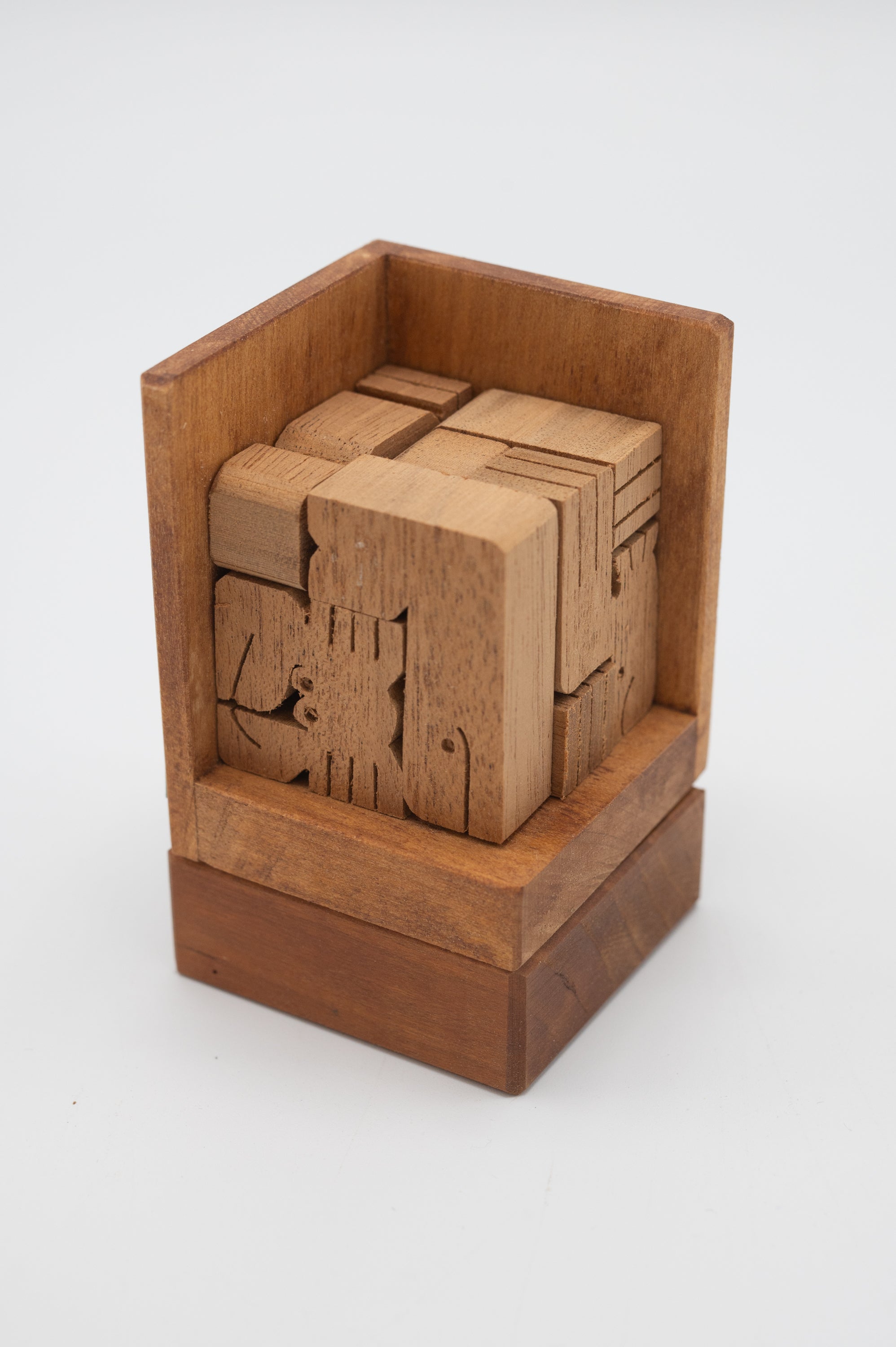 A wooden cube puzzle consisting of various interlocking wooden pieces arranged neatly within a slightly larger wooden box. Each piece showcases intricate engravings of sea animals, enhancing the nautical theme of the puzzle. The cube has a polished finish, displaying a rich, warm wood tone.