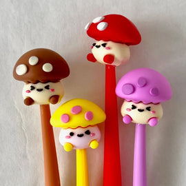 A set of four colorful gel pens designed like cute mushrooms. Each pen features a different friendly mushroom character with vibrant caps and smiling faces, perfect for adding a whimsical touch to writing.