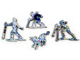 Colorful jigsaw puzzle pieces from the Winterlands collection by Liberty Puzzles, featuring ski figures and a playful dog, each with unique artistic designs.