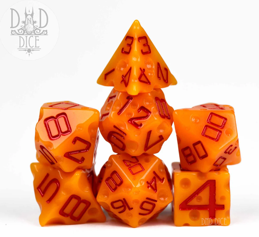 A colorful 7-piece RPG dice set in a vibrant cheese-like orange color with contrasting red numbers. The set includes various shapes like a D20, D12, and others, stacked in an artistic arrangement, showcasing their detailed numeric markings. Ideal for tabletop gaming enthusiasts.