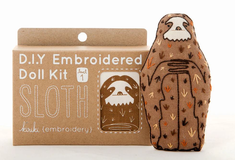 A sloth-themed D.I.Y. embroidery doll kit from Kiriki Press. The kit packaging shows a cute sloth design with various stitching patterns. It is labeled 'level 1' indicating it's suitable for beginners, and features the word 'SLOTH' prominently on the front.