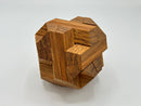 The Egyptian - STC 23A by Stewart Coffin is a beautifully crafted wooden mechanical puzzle. Composed of interlocking pieces made from rich, dark wood, it features a unique design with geometric shapes and intricate details, showcasing expert craftsmanship. The puzzle is displayed from an angle that highlights its three-dimensional form and natural wood grain.