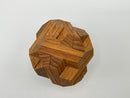 A top view of the Egyptian - STC 23A mechanical puzzle by Stewart Coffin, featuring intricately interlocking wooden pieces in a geometric shape, highlighting varied textures and rich wood tones.