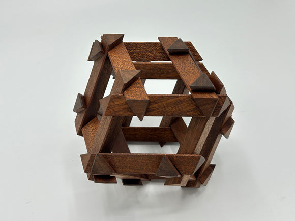 Top view of the RD Skeleton by Dubois, a handcrafted wooden mechanical puzzle featuring intricate interlocking pieces, designed by Philippe Dubois. The puzzle showcases a rich brown finish with pointed accents, enhancing its artistic appeal.